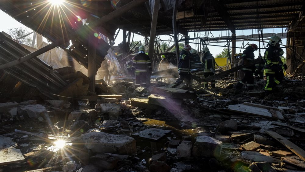 Πυροσβέστες καθαρίζουν τα ερείπια του κατεστραμμένου εμπορικού κέντρου Άμστορ στο Κρεμεντσούκ