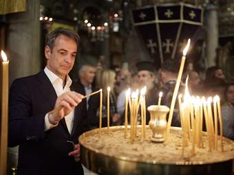 Ο Κ. Μητσοτάκης και η σύζυγός του, Μαρέβα, στην περιφορά του Επιταφίου στην Τήνο